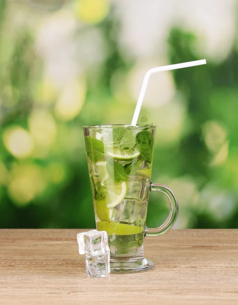 Glas cocktail met limoen en munt op houten tafel groene achtergrond — Stockfoto