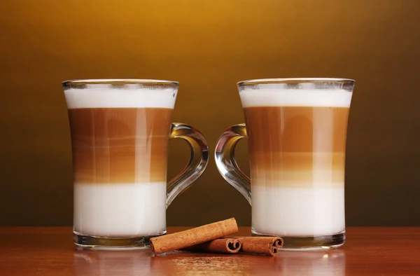 Doftande? offee latte i glas koppar och kanel på träbord på brun b — Stockfoto