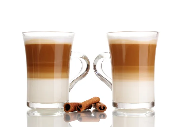 Café con leche fragante en copas de vidrio y canela aislada en blanco —  Fotos de Stock