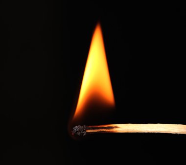 Burning match on black background clipart