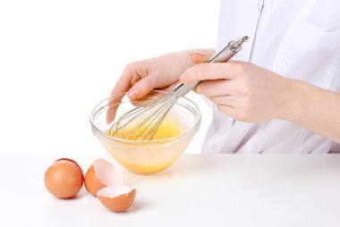 Female hands Mixing eggs in bowl isolated on white clipart