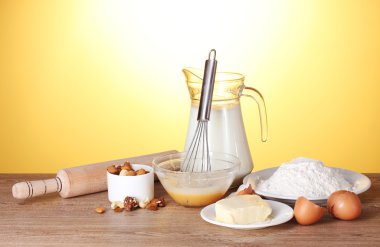 Ingredients for the dough wooden table on yellow background clipart