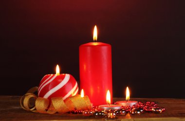 Wonderful candles on wooden table on dark background clipart