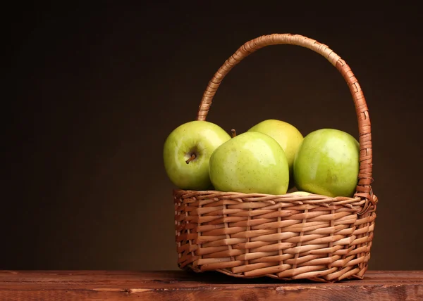 Kosár, fából készült tábla, barna háttér-szaftos zöld alma — Stock Fotó