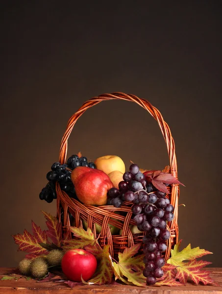 Hermosa cosecha de otoño en cesta y hojas sobre fondo marrón — Foto de Stock