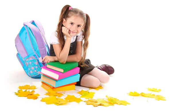 Güzel küçük bir kız, kitap ve üzerinde beyaz izole bir sırt çantası — Stok fotoğraf