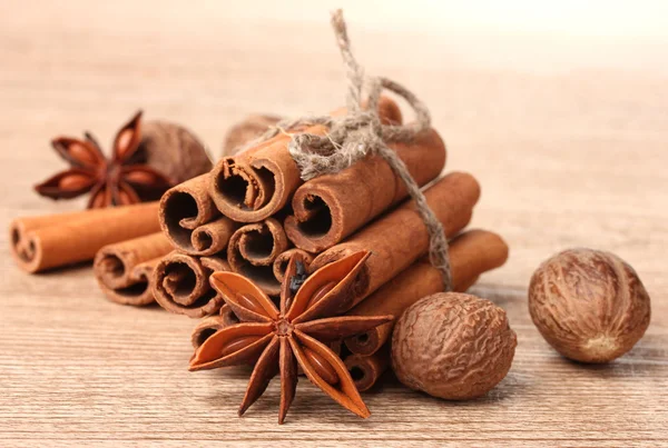 Palitos de canela, nuez moscada y anís sobre mesa de madera — Foto de Stock