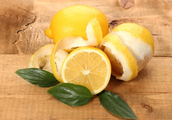 Reife Zitronen mit Blättern auf Holztisch — Stockfoto