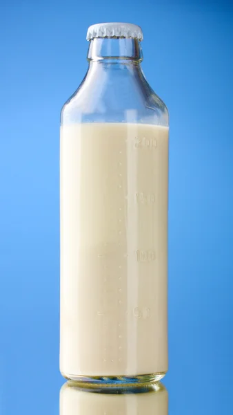 Botella de leche sobre fondo azul — Foto de Stock