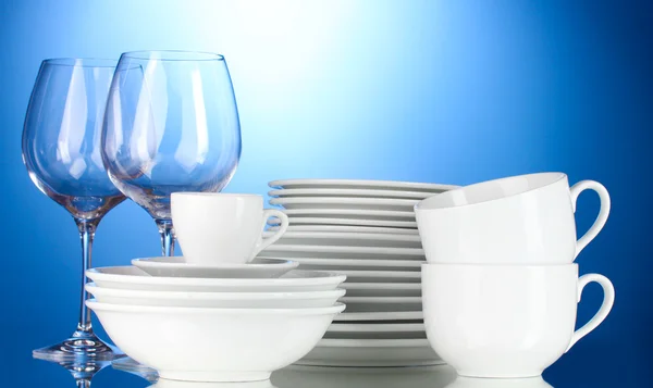 Cuencos vacíos, platos, tazas y vasos sobre fondo azul — Foto de Stock