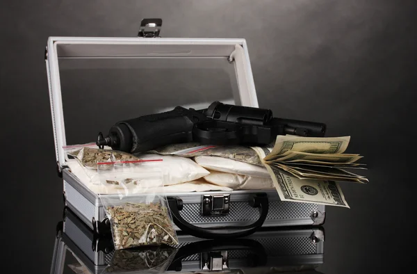 Kokain und Marihuana mit Pistole im Koffer vor grauem Hintergrund — Stockfoto