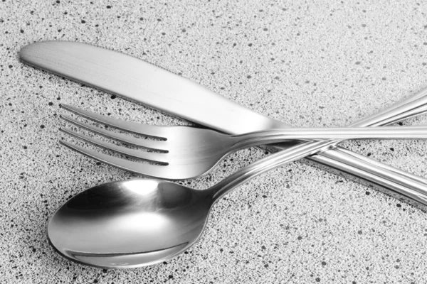 Widelec, łyżka i nóż na marmurowy stół — Zdjęcie stockowe