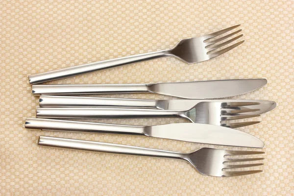 Fourchettes et couteaux sur une nappe beige — Photo