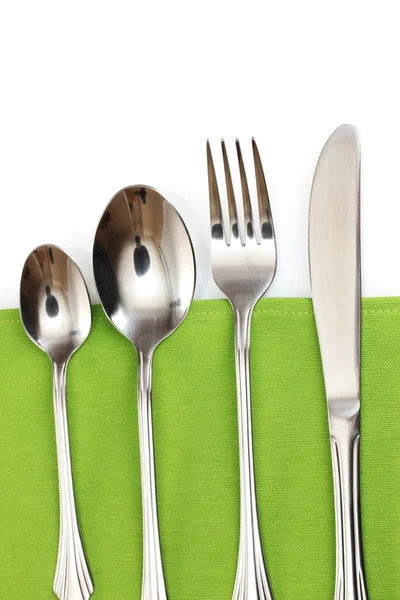 Garfo, colher e faca em uma toalha de mesa verde — Fotografia de Stock
