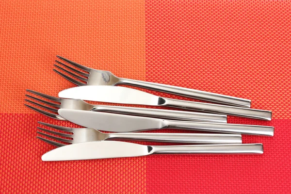 Forchette e coltelli su una tovaglia rossa — Foto Stock