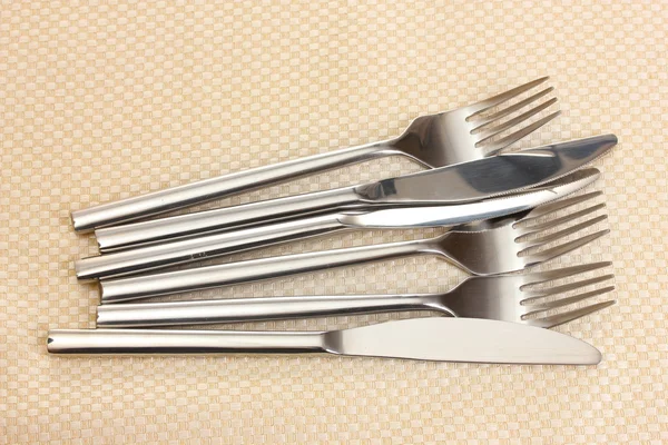 Gabeln und Messer auf einer beigen Tischdecke — Stockfoto