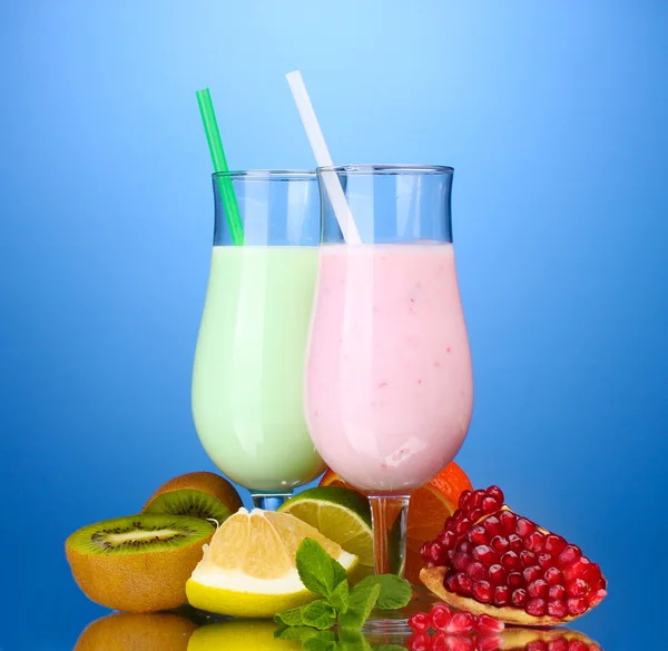 Melk schudt met vruchten op blauwe achtergrond — Stockfoto