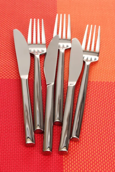Fourchettes et couteaux sur une nappe rouge — Photo