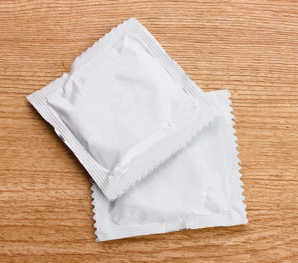 Jeden kondom na dřevěné pozadí — Stock fotografie