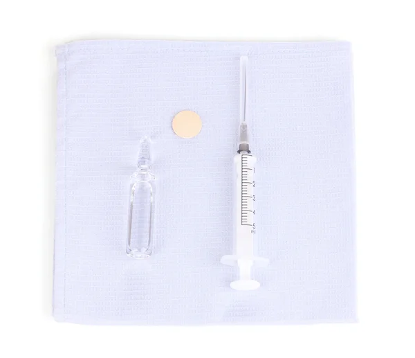 Seringa e ampola médica em guardanapo isolado em branco — Fotografia de Stock