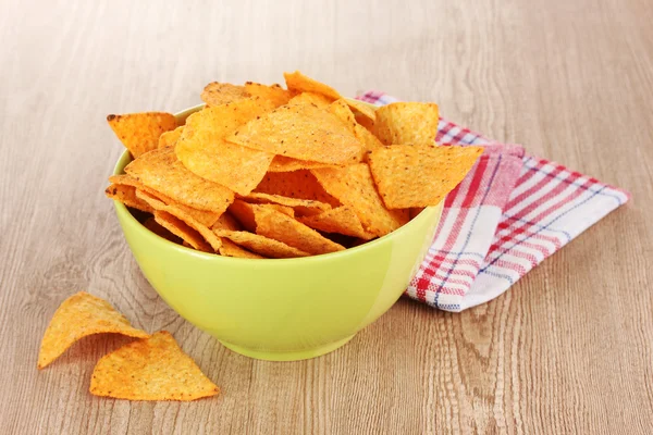 Tasty potato chips in green bowl on wooden table — Stock Photo, Image