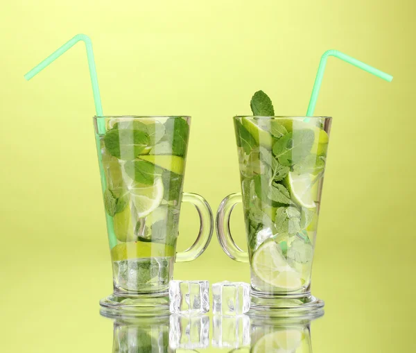 Briller av cocktail med kalk og mynte på grønn bakgrunn – stockfoto