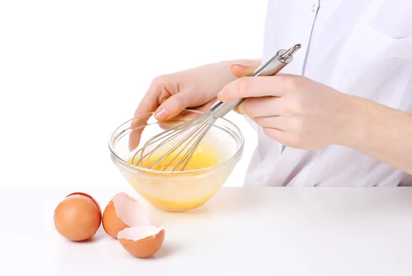 Manos femeninas Mezclando huevos en un tazón aislado sobre blanco — Foto de Stock
