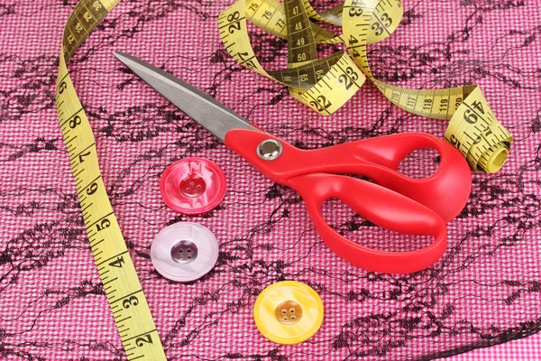 Ножницы, кнопки, измерительная лента и узор на ткани — стоковое фото