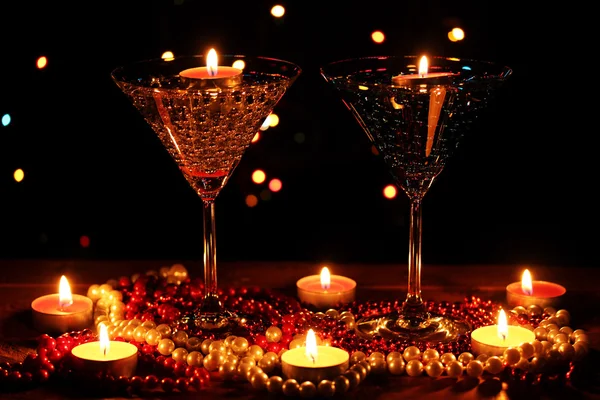 Increíble composición de velas y vasos sobre mesa de madera sobre fondo brillante —  Fotos de Stock