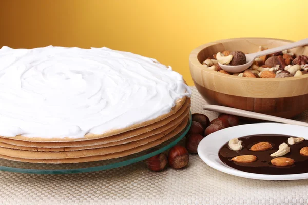Tårta på glas stå och nötter på bordet på gul bakgrund — Stockfoto