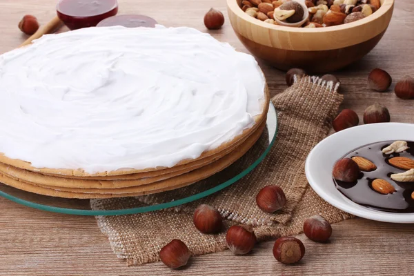 Stock image Cake on glass stand and nuts on wooden table