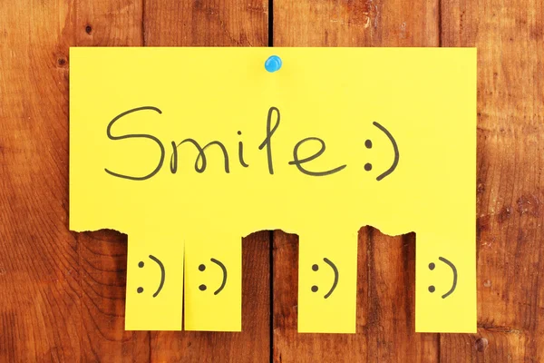 Barevná reklama úsměv na dřevěné pozadí — Stock fotografie