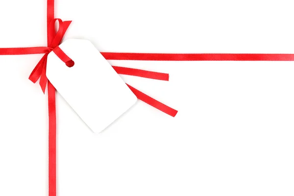 Lege geschenk label met strik op rode satijnen lint geïsoleerd op wit — Stockfoto