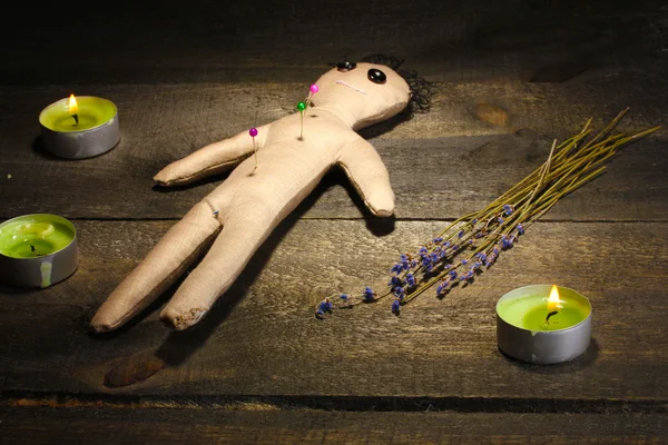Voodoo boneco menino em uma mesa de madeira à luz das velas Fotografias De Stock Royalty-Free