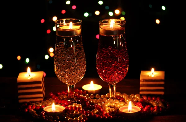 Amazing composition of candles and glasses on wooden table on bright backgr — Stock Photo, Image