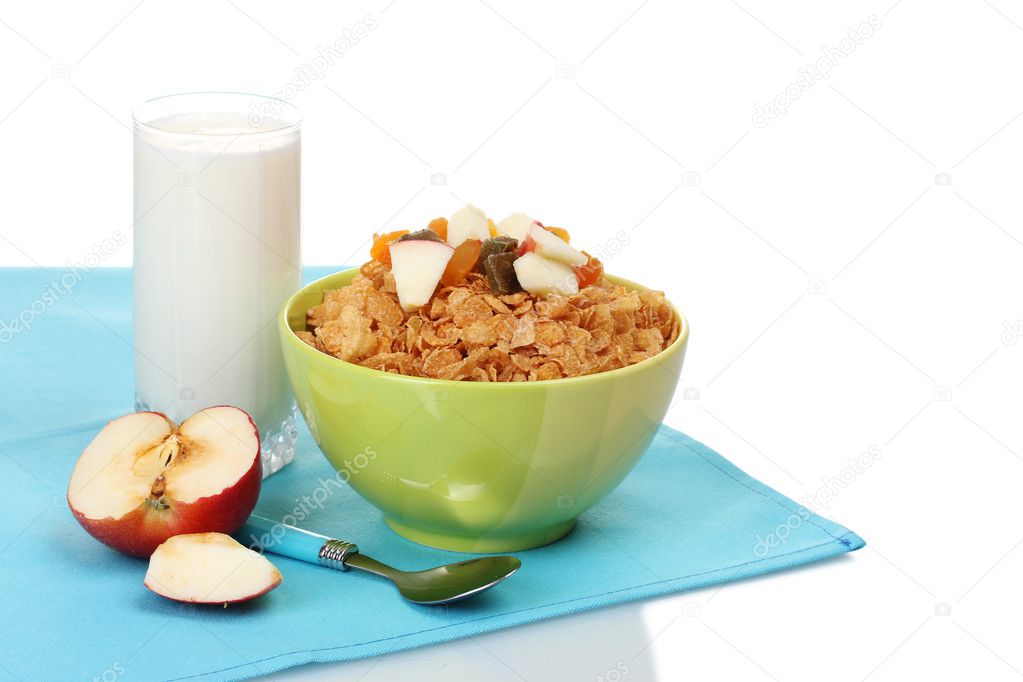 Tasty cornflakes in bowl with dried fruits, glass of milk and apple on blue