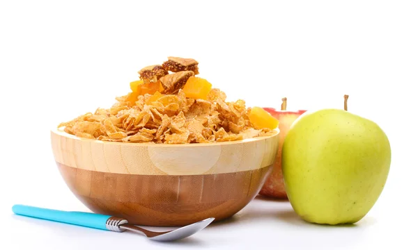 Tasty cornflakes in wooden bowl and apples isolated on white — Stock Photo, Image