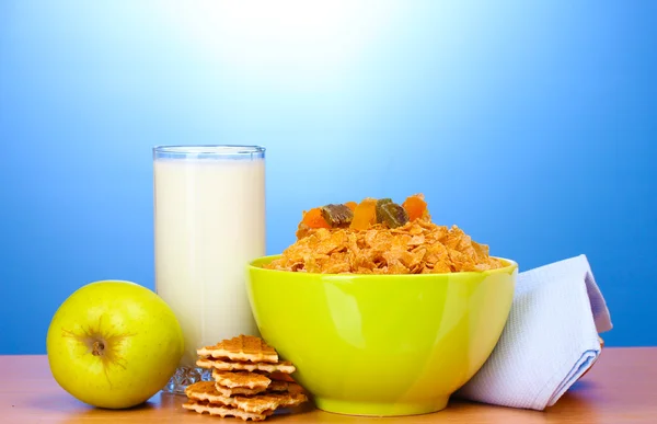 Chutné kukuřičné lupínky v zelené prohlubni, jablka a sklenici mléka na dřevěný stůl na — Stockfoto