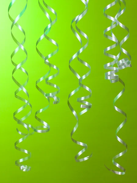 Schöne Luftschlangen auf grünem Hintergrund — Stockfoto