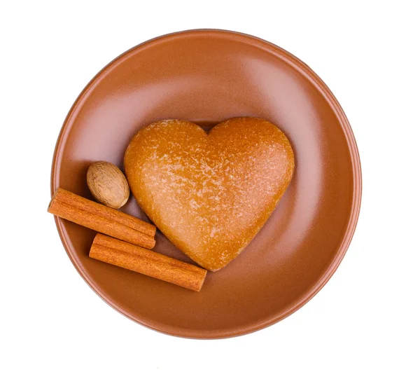 Biscotto a forma di cuore con cannella e noce moscata su piattino isolato su bianco — Foto Stock