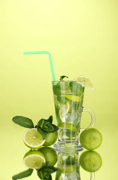 Vaso de cóctel con lima y menta sobre fondo verde — Foto de Stock