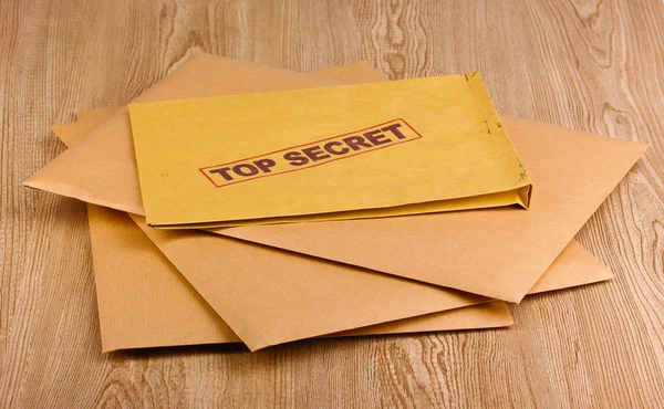 Envelopes com selo ultra secreto em fundo de madeira — Fotografia de Stock