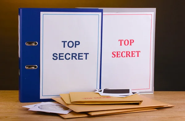 Enveloppen en mappen met top geheime stempel en foto papier met cd schijven — Stockfoto