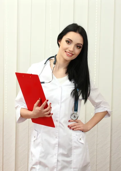 Mladá krásná doktor předávající složky — Stock fotografie