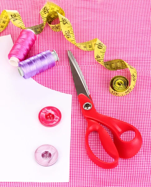 Scissors, threads, buttons, measuring tape and pattern on fabric isolated o — Stock Photo, Image