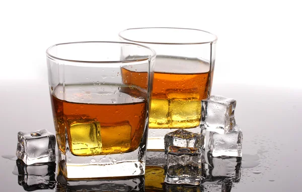 Twee glazen van scotch whisky en ijs op tafel geïsoleerd op wit — Stockfoto