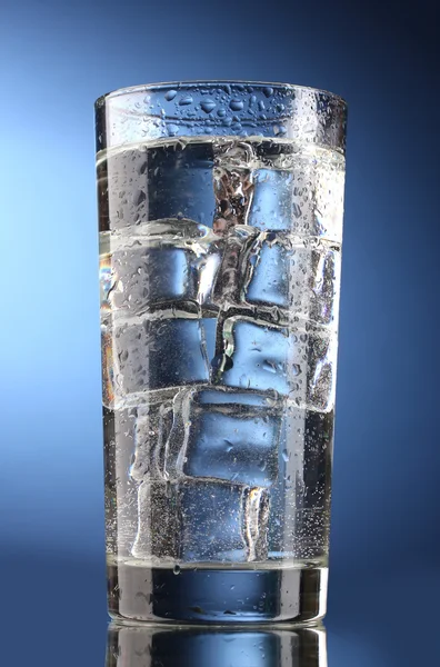 Verre d'eau avec glace sur fond bleu — Photo
