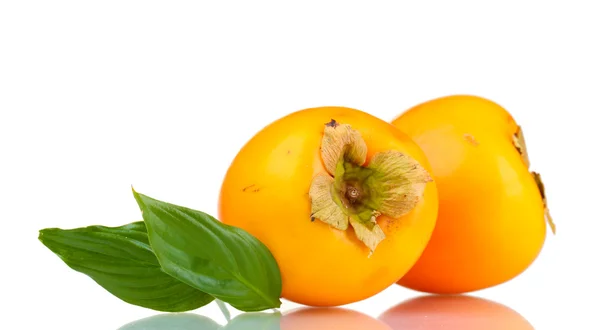 Two appetizing persimmons with green leaves isolated on white — Stock Photo, Image