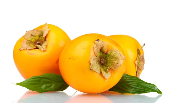 Trzy apetyczny persimmons z zielonych liści na białym tle — Zdjęcie stockowe