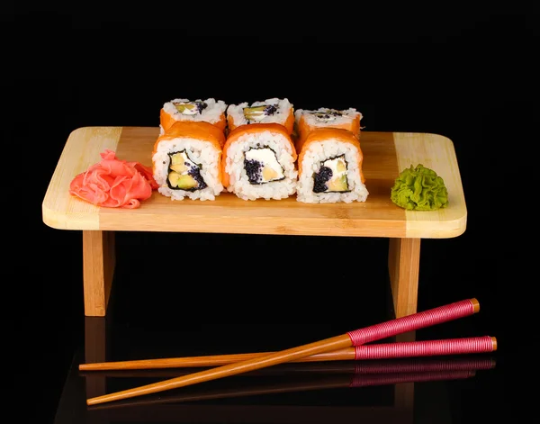Tasty rolls served on wooden plate isolated on black — Stock Photo, Image